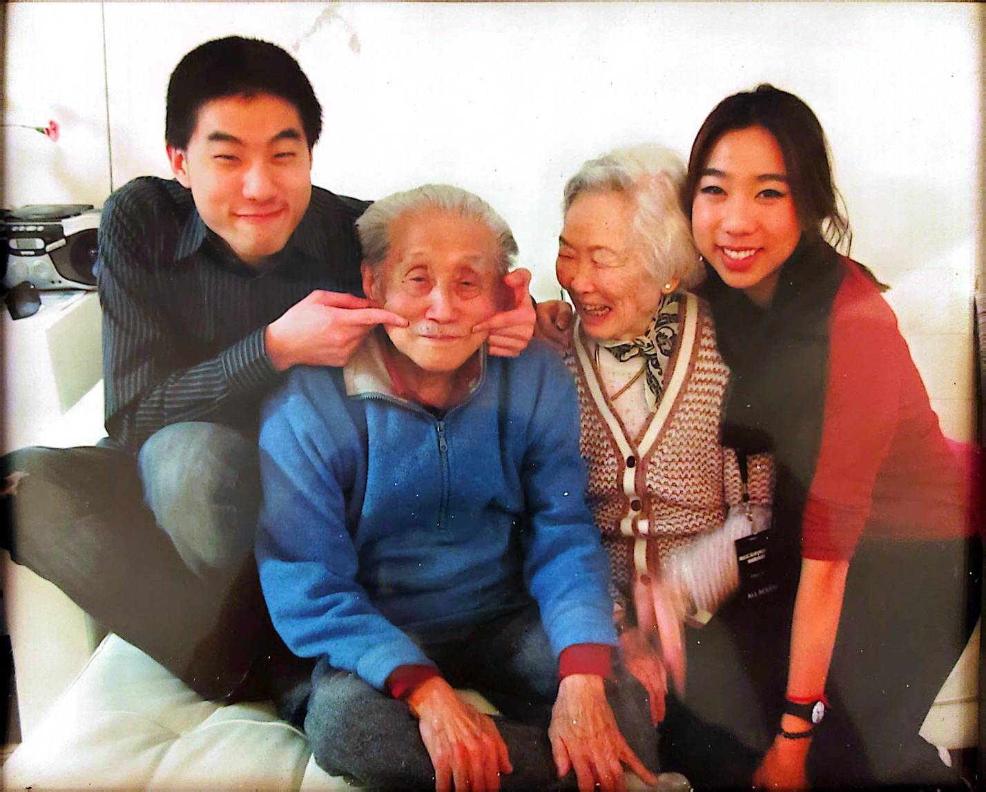 祖孫:這幅美麗的自然照片展示了丁大師與愛妻紀鳳被孫輩圍繞的溫馨時刻。這張照片捕捉了定義丁氏家風的輕鬆幽默與深厚情感。